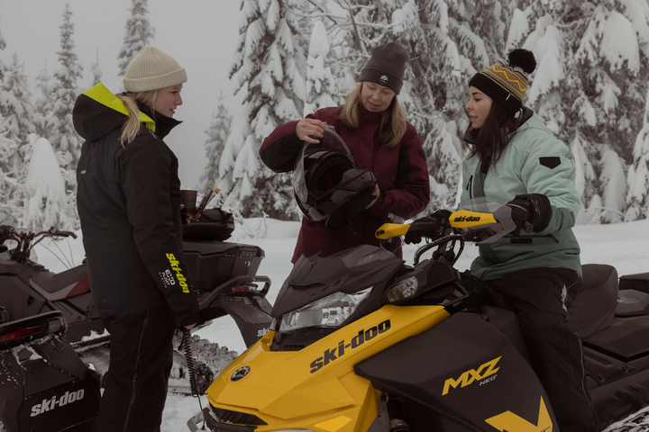 action shot of girl riding in deep snow. Half in the air with gear from head to toe. 